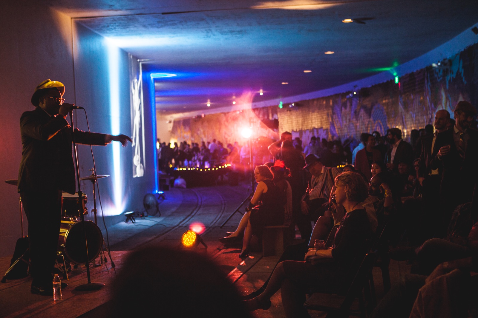 A singer performing to a crowd on the platform of the Dupont Underground